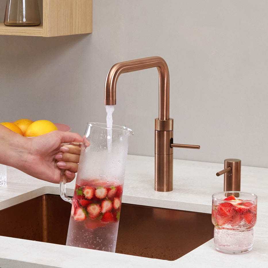 Filling a jug of strawberry water from a rose copper Quooker Fusion Square