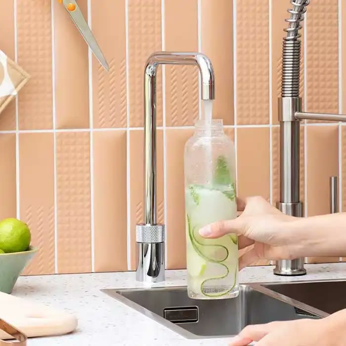 A chrome Quooker Nordic Square tap beside a pull-out mixer, filling a glass bottle